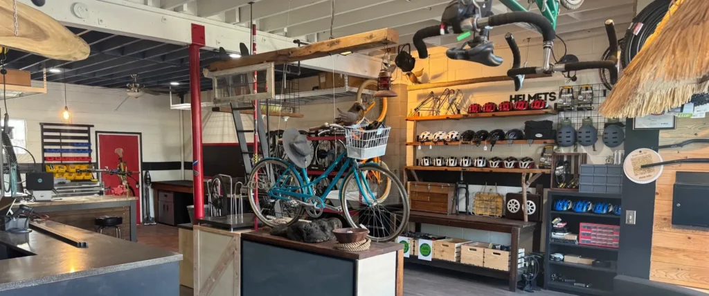 Bike shop showing a bike on a table and cycling equipment on shelves.
